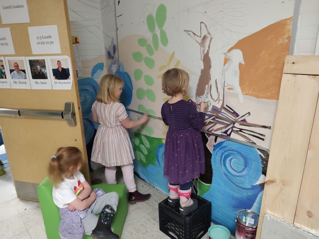 Students helping to paint the lobby mural.