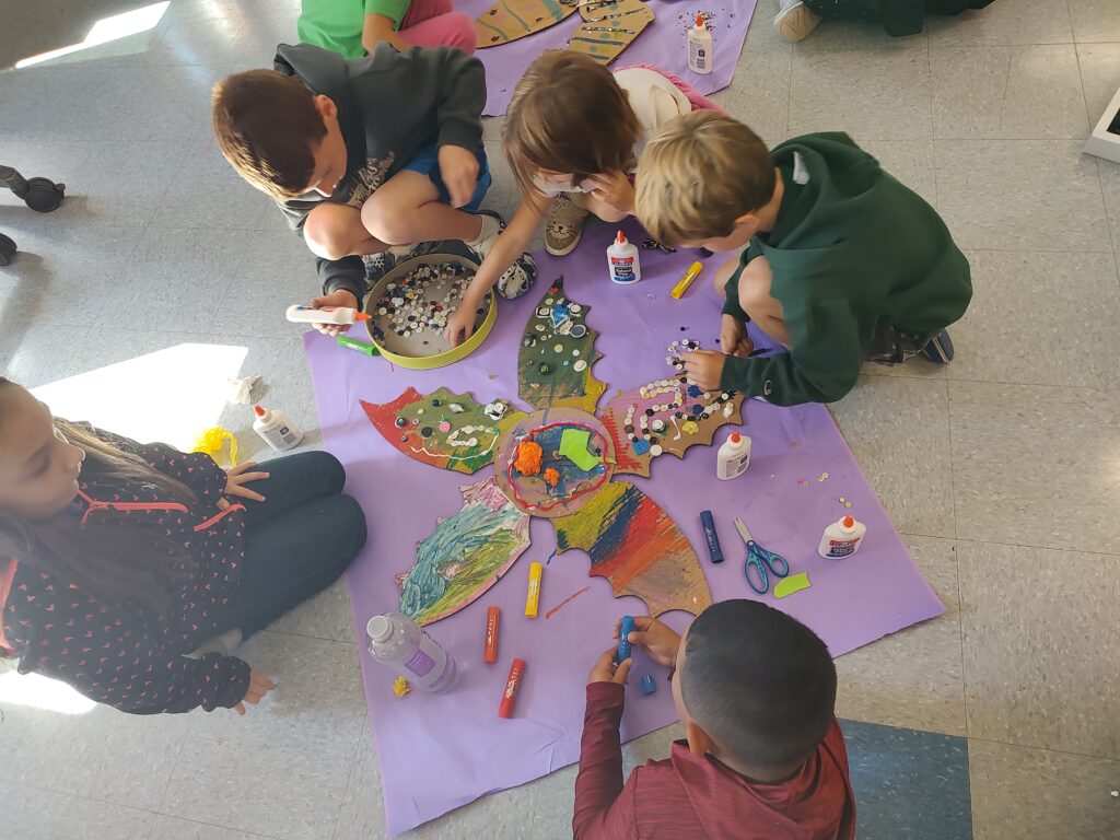 Students adding beads to their flower designs.