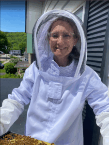 Photo of Elizabeth in beekeeping suit