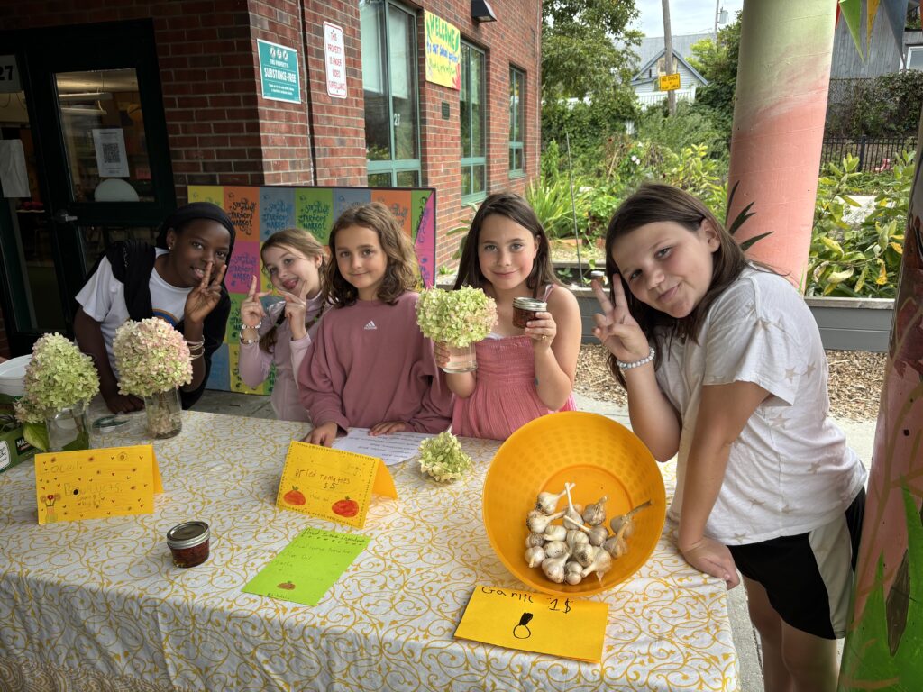 Students sell flowers at the table.